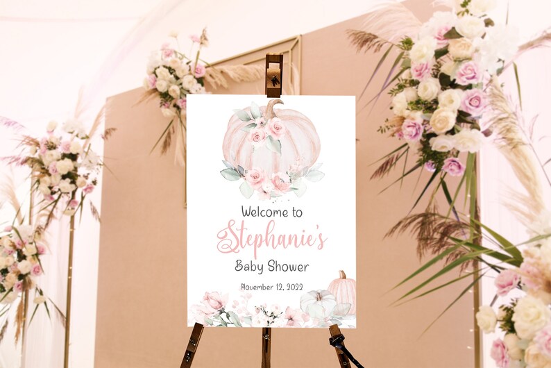 May include: Welcome to Stephanie's Baby Shower sign with a watercolor illustration of a pink and white pumpkin with flowers and greenery. The sign also includes the date November 12, 2023.