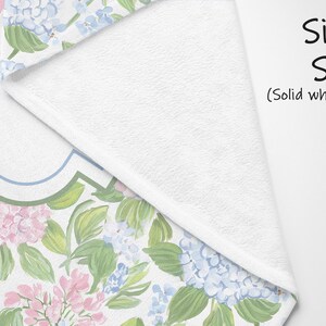 Puede incluir: Una manta de una sola cara con reverso blanco s&oacute;lido y un patr&oacute;n floral en el frente que presenta racimos de hortensias rosas y azul claro con hojas verdes. El texto "Single Sided (Solid white back)" est&aacute; impreso en negro a la derecha.