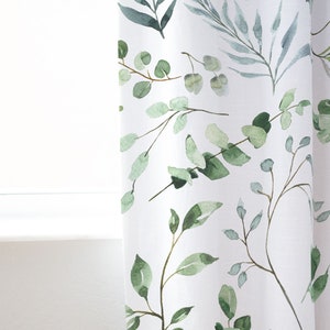 May include: White curtain panel with a watercolor botanical design. The pattern features green and blue-green leaves and branches. The curtain is near a white window frame.