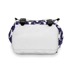 May include: A white backpack with adjustable straps. The backpack has a navy blue background with a white deer silhouette pattern.