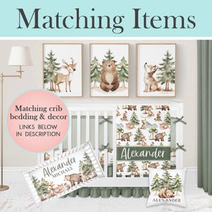 Op de afbeelding: Een kinderkamer set met een bos thema. De set bevat ingelijste kunst met illustraties van herten, beren en vossen, beddengoed, een kussen en een wieg bumper. De tekst "Matching Items" en "Alexander" zijn zichtbaar.