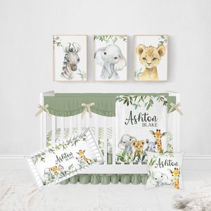 May include: A green and white crib bedding set with a jungle animal theme. The set includes a fitted sheet, a crib skirt, a blanket, and two pillowcases. The blanket features a leafy design with the names Ashton Blake. The pillowcases feature a leafy design with a giraffe, elephant, lion, and zebra.