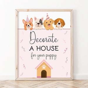 May include: A pink and white printable sign with four cartoon dogs wearing party hats. The sign says "Decorate a house for your puppy" and has a cartoon dog house with a paw print on the roof.