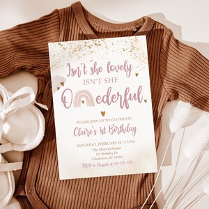 May include: A pink and gold first birthday invitation with a rainbow and the text "Isn't she lovely, Isn't she Oederful." The invitation includes the birthday girl's name, date, time, and location.