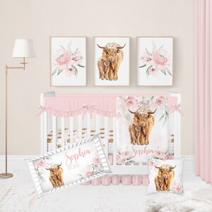 May include: A nursery set featuring a white crib with pink bedding, a floral blanket, and a decorative pillow. Above the crib are three framed prints: two with watercolor Highland cow illustrations and one with pink floral art. The set includes a personalized pillow with the name "Sophia Rose".
