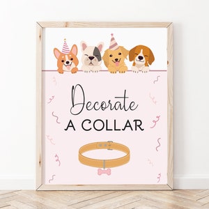 May include: A pink and white sign with four dogs wearing party hats. The sign says "Decorate A Collar" and has a brown collar with a bone charm.