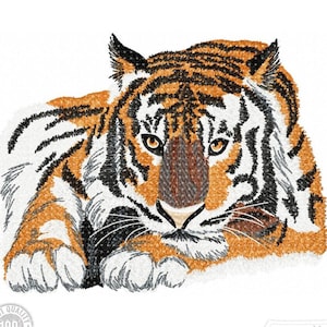 Könnte beinhalten: Nahaufnahme eines gestickten Tigers mit orangefarbenen, schwarzen und weißen Streifen. Der Tiger liegt mit erhobenem Kopf und blickt direkt auf den Betrachter. Die Augen des Tigers sind offen und aufmerksam.