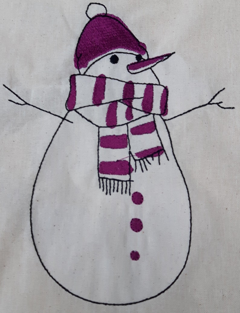以下が含まれることがあります： 手縫いの雪だるま。紫色の帽子とマフラーをしています。雪だるまは黒いボタンが3つと黒い鼻をしています。