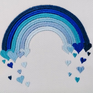 May include: Embroidered design of a blue rainbow with a cascade of blue hearts falling from the arch.