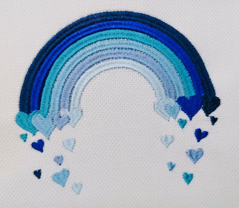 May include: Embroidered design of a blue rainbow with a cascade of blue hearts falling from the arch.