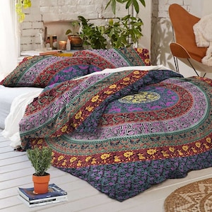 Op de afbeelding: Een bohemian stijl dekbedovertrek met een mandala-patroon in tinten rood, paars, groen en geel. Het dekbedovertrek is gemaakt van katoen en heeft een bloemenontwerp.