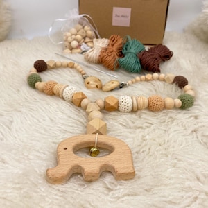 Puede incluir: Un kit de mordedor para bebé de bricolaje con cuentas de madera, elementos de ganchillo y un sonajero de elefante de madera. El kit incluye una caja de cuentas de madera, hilo de diferentes colores y un sonajero de elefante de madera.