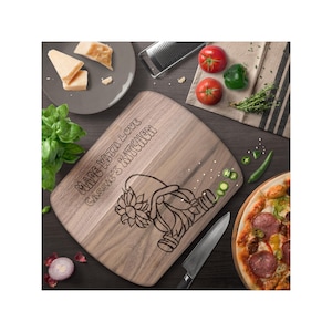 May include: A brown wooden cutting board with the text "Made with love Cassie's Kitchen" engraved on it. A cartoon gnome with a sunflower is also engraved on the board.
