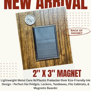 The image is an advertisement for a new arrival of a 2" x 3" magnet. It features a close-up of the magnet on a wooden surface, along with a coin placed next to it. The magnet is described as a light metal core with a plastic protector over eco-friendly ink, designed for use with fridges, lockers, toolboxes, file cabinets, and magnetic boards. The advertisement also includes a size comparison, stating that a business card is typically 2" x 3.5".