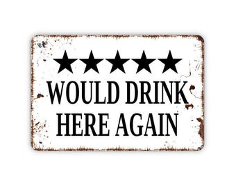 May include: A rectangular metal sign with a white background and distressed brown edges. The sign features five black stars in a horizontal row above the black text "WOULD DRINK HERE AGAIN" printed in a bold, serif font centered on the surface.
