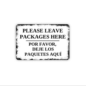 May include: A rectangular sign with a white background and black distressed edges. The text reads PLEASE LEAVE PACKAGES HERE followed by a horizontal line and the Spanish text POR FAVOR, DEJE LOS PAQUETES AQUÍ in black capital letters.