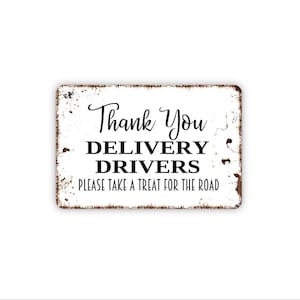 May include: A rectangular white metal sign with distressed brown edges. The text reads Thank You in a script font, followed by DELIVERY DRIVERS in bold capital letters, and PLEASE TAKE A TREAT FOR THE ROAD in a simple sans-serif font.
