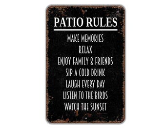 May include: A rectangular metal sign with a distressed black finish and rust-colored edges. The white text reads: PATIO RULES, MAKE MEMORIES, RELAX, ENJOY FAMILY & FRIENDS, SIP A COLD DRINK, LAUGH EVERY DAY, LISTEN TO THE BIRDS, WATCH THE SUNSET.