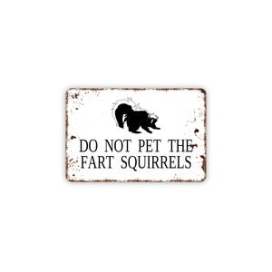 May include: A rectangular metal sign with a white background and distressed brown edges. It features a black graphic of a skunk and the black text DO NOT PET THE FART SQUIRRELS centered on the surface in a clear, sans-serif font style.