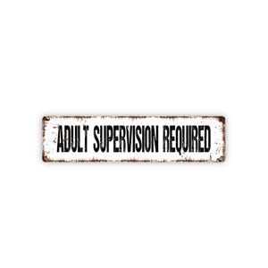 May include: A rectangular metal sign with a white background and the words "ADULT SUPERVISION REQUIRED" in bold black letters. The sign has a distressed, rusty brown border, giving it a vintage appearance.