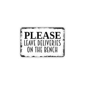 May include: A rectangular white sign with a distressed black border and black text that reads PLEASE LEAVE DELIVERIES ON THE BENCH. The sign features a clean, bold font for the word PLEASE and a thinner, sans-serif font for the remaining text.