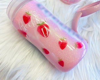 May include: Pink glitter tumbler with a white design of strawberries and the name "Beckham" with a letter "D" in the middle.