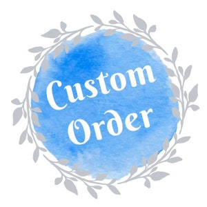 May include: A round design with a blue watercolor background and the words "Custom Order" in white script. The text is centered within the blue circle, which is surrounded by a gray floral wreath.