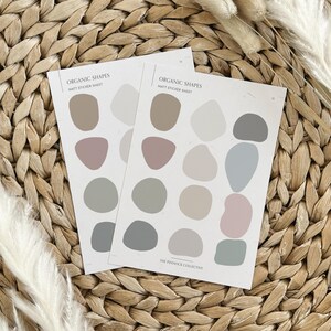 K&ouml;nnte beinhalten: Zwei Bl&auml;tter mattes Aufkleberpapier mit organischen Formen in verschiedenen Braunt&ouml;nen, Graut&ouml;nen und Rosat&ouml;nen. Der Text "Organic Shapes" und "Matte Sticker Sheet" ist auf jedem Blatt gedruckt. Der Text "The Pinnock Collective" ist auf der Unterseite eines Blattes gedruckt.