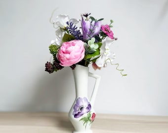 Brocca vintage in ceramica a forma di papavero con un grazioso mazzolino di fiori artificiali nei toni del viola e del rosa.