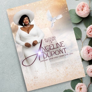 May include: A memorial card with a white dove flying in a golden sky. The card features a photo of a woman wearing a white hat and dress. The text reads "In loving memory of Angeline Dupont, January 13th, 1963 - June 9th, 2021."