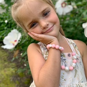 Soft pink & Pearl silicone necklace beads and stretch bracelet beautifully bundled as a set, perfect for dressing up. Kids love the ability to adorn themselves with jewelry, and our durable double threaded elastic helps them with independently play!