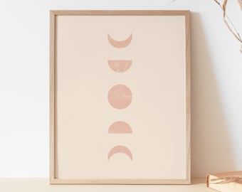 Könnte beinhalten: Ein gerahmter Druck mit einem minimalistischen Design, das eine Reihe von rosa Mondphasen auf einem beigefarbenen Hintergrund zeigt.