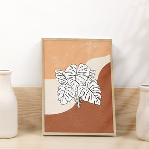 May include: A framed print with a minimalist design featuring a white outline of tropical leaves on a background of orange, brown, and cream.
