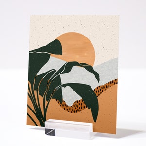 May include: Abstract art print featuring a stylised sunset with a large orange sun and green leaves. The background is a light beige with a subtle speckled texture.