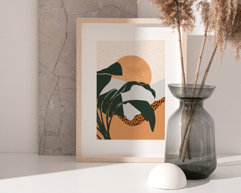 May include: A framed print with a minimalist design featuring a stylized sunset with green leaves and a light orange background.