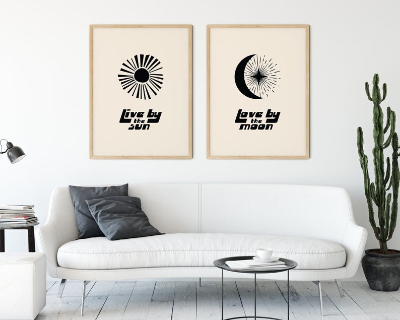 Puede incluir: Dos p&oacute;sters minimalistas en blanco y negro con un dise&ntilde;o de sol y luna. El texto en los p&oacute;sters dice "Live by the sun" y "Love by the moon".