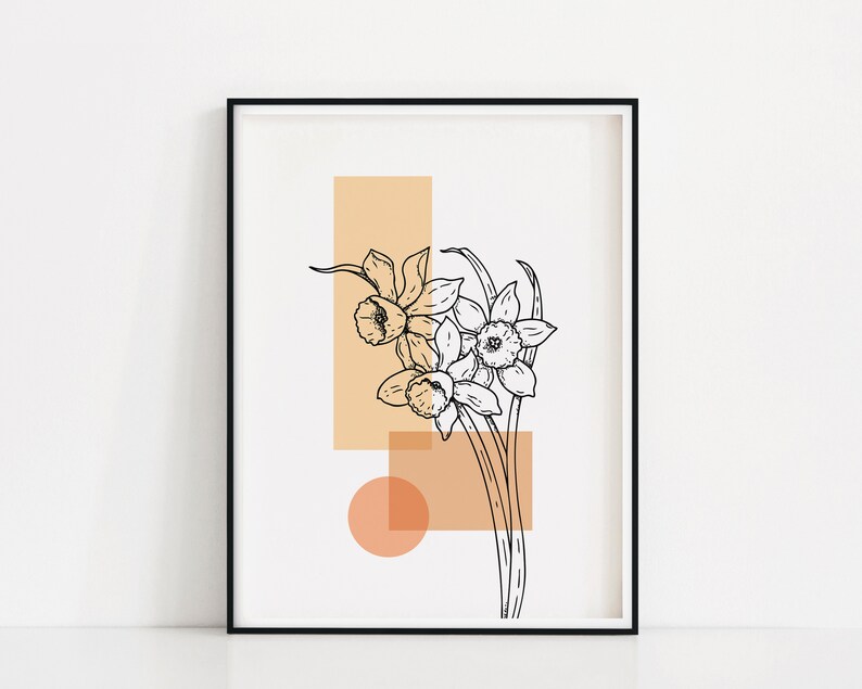 May include: A black and white line drawing of daffodils with peach and orange geometric shapes behind them. The image is framed in a black frame.