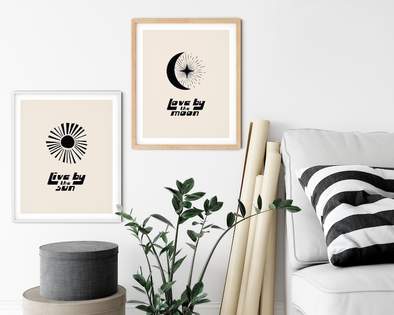 Puede incluir: Dos impresiones minimalistas en blanco y negro con un dise&ntilde;o de sol y luna. La impresi&oacute;n del sol dice "Live by the sun" y la impresi&oacute;n de la luna dice "Love by the moon".