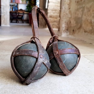 Gorgeous pair of antique, French, solid bronze "pétanque" boule in their original leather carry strap. Circa early 1900's