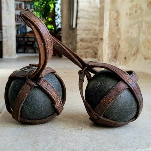 Gorgeous pair of antique, French, solid bronze "pétanque" boule in their original leather carry strap. Circa early 1900's