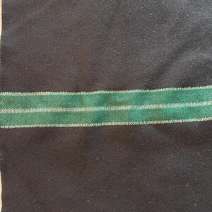 May include: A dark navy blue fabric with a horizontal green stripe with white accents. The fabric has a textured appearance. A small tag with the numbers "20177-2 2968 M64" is in the upper left corner.