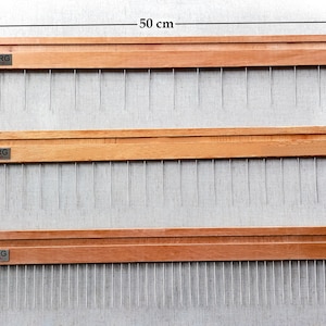 May include: Three wooden tools with metal pins, each measuring 5.5 cm long and 50 cm wide. The tools are labelled "VASTORG" and have different lengths of pins, measuring 1 cm, 2 cm, and 3 cm.