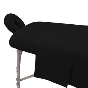 May include: Black massage table with a black fitted sheet and a black face cradle.