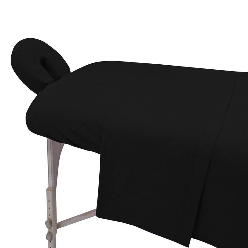May include: Black massage table with a black fitted sheet and a black face cradle.