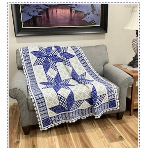 May include: A blue, white, and gray Blackwork Star Flower Afghan crochet pattern draped over a gray armchair. The afghan features large star designs and decorative borders. The text "Blackwork Star Flower Afghan" is visible.