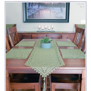 Könnte beinhalten: Ein salbeigrünes Häkel-Tischset bestehend aus einem langen Tischläufer mit spitz zulaufenden Enden und Quasten sowie vier passenden quadratischen Platzdeckchen. Der Text Collage of Leaves Table Set ist oben im Bild zu sehen.