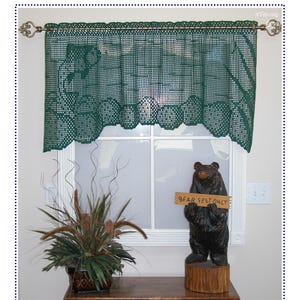 May include: A dark green crochet valance featuring a fish-themed pattern hanging on a metal rod. The valance has a scalloped bottom edge and a grid-like texture. The text "Gone Fishin' Valance" and "Kathryn Clark Crochet" appear at the top.