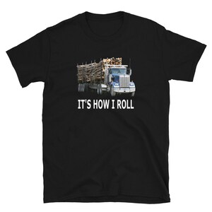 Op de afbeelding: Zwart T-shirt met een blauwe vrachtwagen die een lading hout vervoert. De tekst "It's how I roll" is in wit onder de vrachtwagen gedrukt.