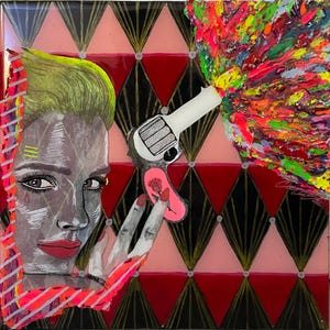 Può includere: Opera d'arte astratta raffigurante il volto di una donna con capelli verdi e labbra rosse. Una pistola bianca è puntata verso destra, con un'esplosione di vernice colorata. Lo sfondo presenta un motivo a rombi in nero, rosso e rosa.