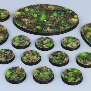 May include: A set of 13 green and brown round and oval-shaped bases for miniature wargaming. The bases are painted with a green and brown mossy texture and have a black rim.